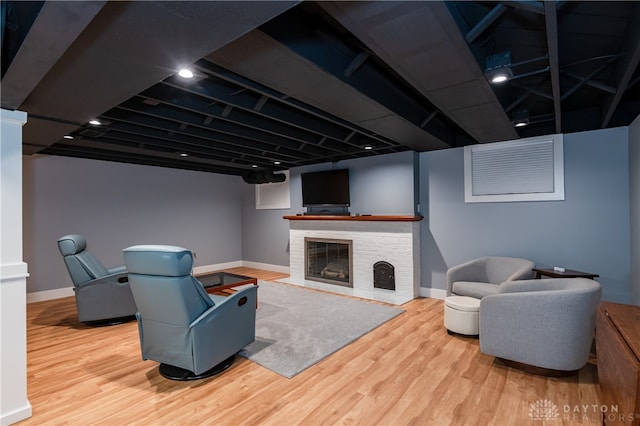 living room featuring wood-type flooring and a brick fireplace