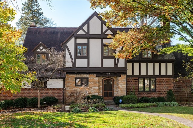 tudor home with a front lawn and a garage