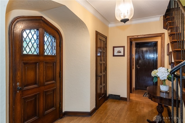 entryway with hardwood / wood-style floors and ornamental molding