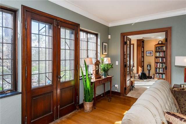 doorway to outside featuring crown molding, french doors, and light wood-type flooring