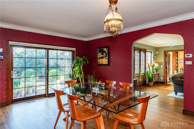 dining area featuring a chandelier, light hardwood / wood-style floors, and ornamental molding