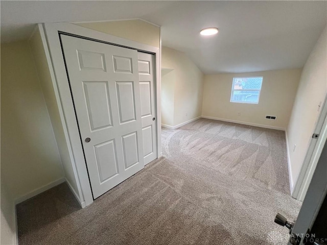 bonus room with light colored carpet and lofted ceiling