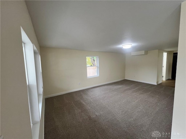 spare room featuring dark colored carpet