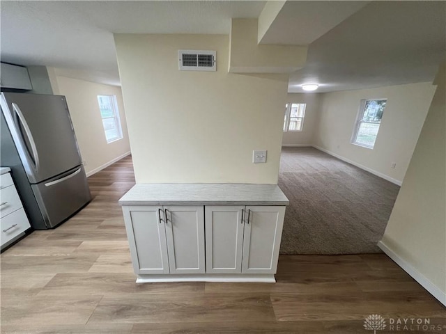 interior space with light carpet and stainless steel refrigerator