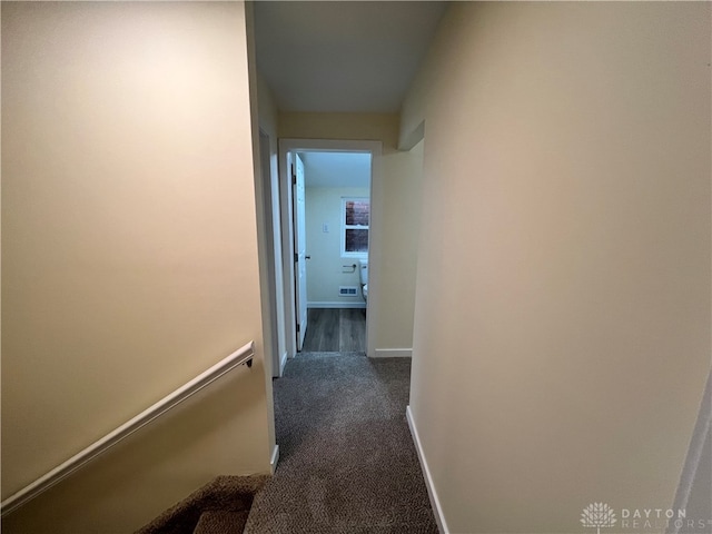 hallway with dark colored carpet