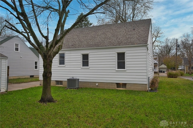 view of side of property with a yard and central air condition unit