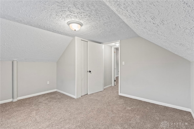 bonus room with carpet, lofted ceiling, and a textured ceiling