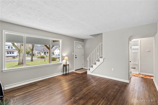 interior space with a baseboard heating unit, a textured ceiling, and dark wood-type flooring