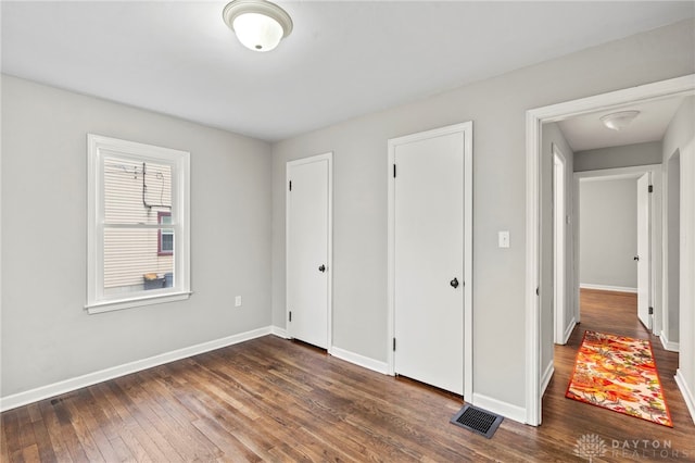 unfurnished bedroom with dark hardwood / wood-style flooring