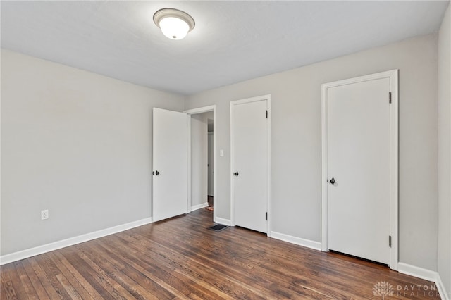 unfurnished bedroom with dark hardwood / wood-style flooring