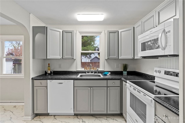 kitchen featuring a healthy amount of sunlight, white appliances, gray cabinetry, and sink