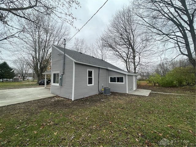 rear view of property with a yard and central air condition unit