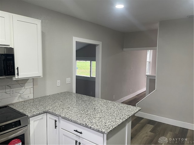 kitchen with light stone counters, dark hardwood / wood-style flooring, white cabinets, and stainless steel appliances