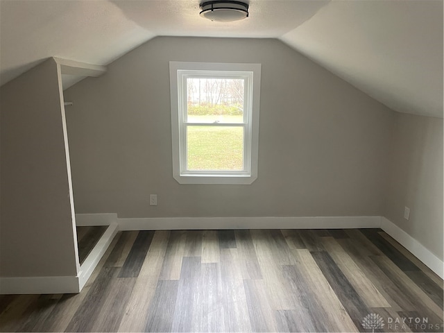 bonus room with dark wood-type flooring and lofted ceiling