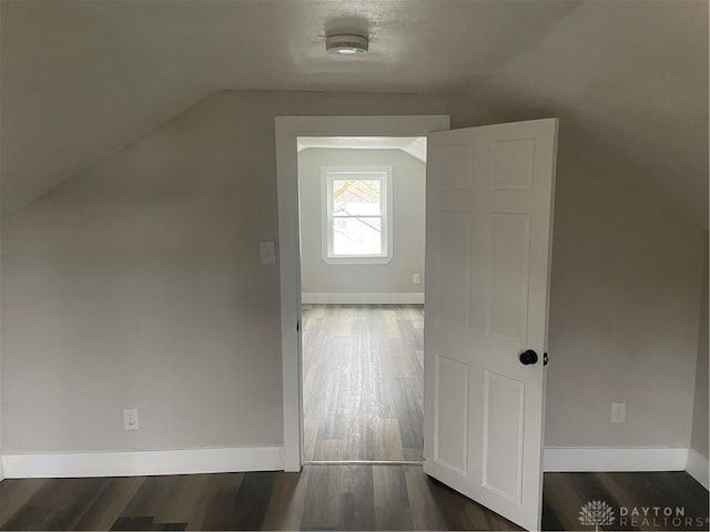 bonus room featuring a textured ceiling, dark wood-type flooring, and vaulted ceiling