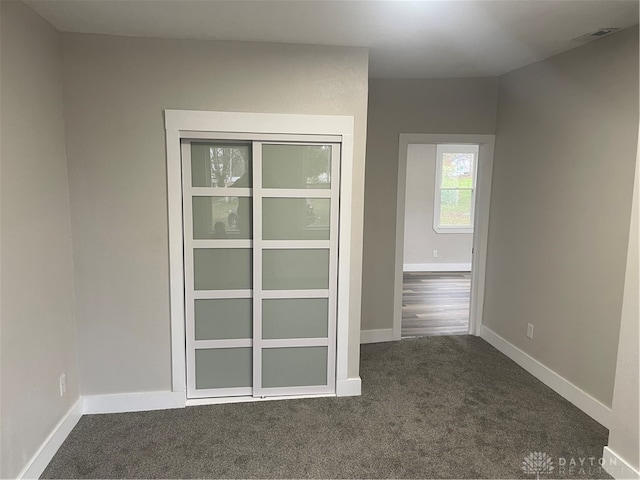 spare room with dark colored carpet