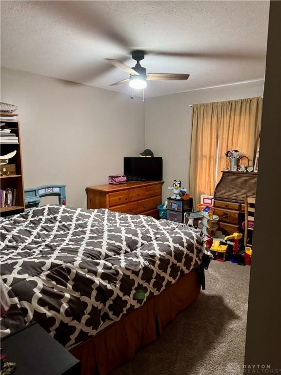 bedroom featuring ceiling fan, carpet flooring, and a textured ceiling