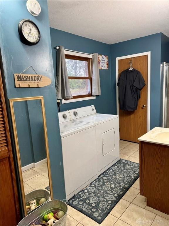 clothes washing area featuring light tile patterned floors and washing machine and dryer