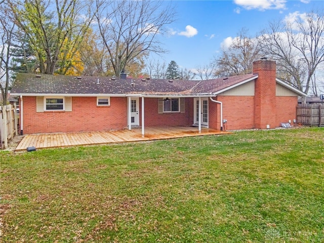 back of house with a wooden deck and a lawn