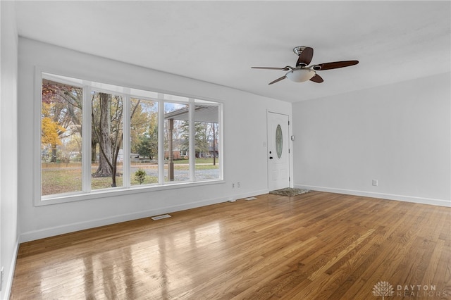 unfurnished room with hardwood / wood-style flooring, ceiling fan, and a wealth of natural light