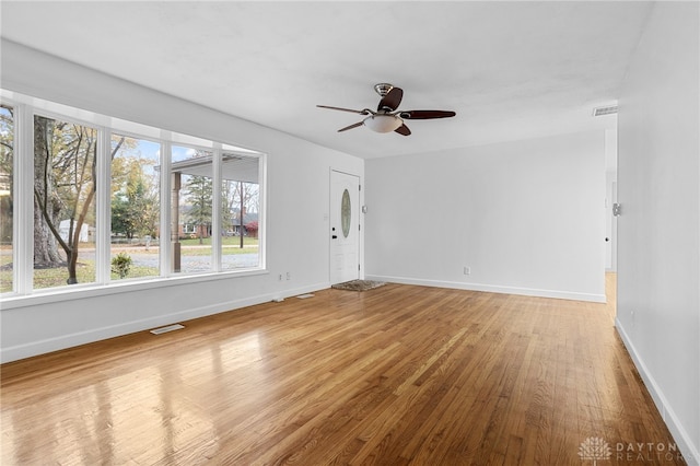 unfurnished room with hardwood / wood-style floors, plenty of natural light, and ceiling fan