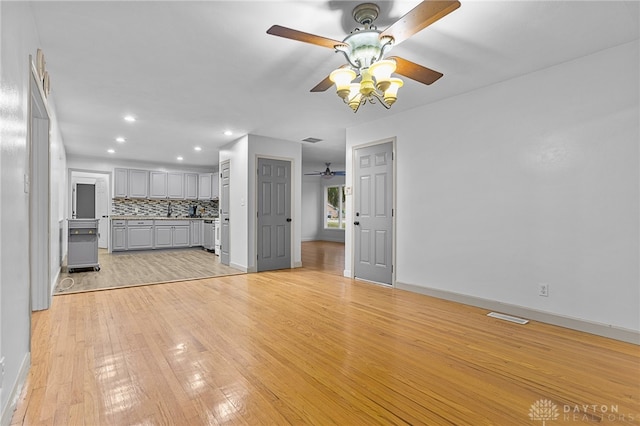 unfurnished living room with ceiling fan and light wood-type flooring