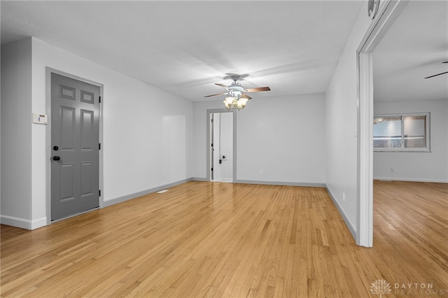 empty room with ceiling fan and light hardwood / wood-style floors