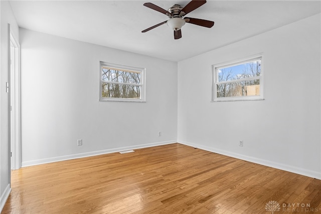 spare room featuring ceiling fan, light hardwood / wood-style floors, and a wealth of natural light