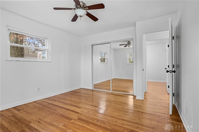 unfurnished bedroom featuring a closet, light hardwood / wood-style flooring, and ceiling fan