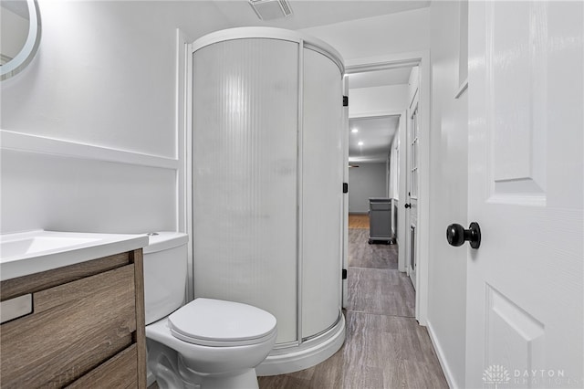 bathroom with vanity, hardwood / wood-style flooring, toilet, and walk in shower