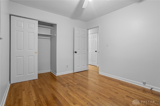 unfurnished bedroom featuring a closet, light hardwood / wood-style flooring, and ceiling fan