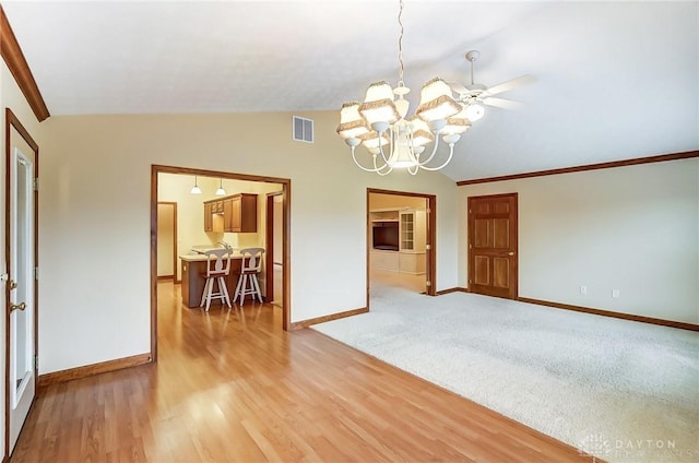 unfurnished room featuring ceiling fan with notable chandelier, ornamental molding, lofted ceiling, and light wood-type flooring