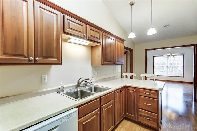 kitchen with decorative light fixtures, lofted ceiling, dishwasher, a chandelier, and sink