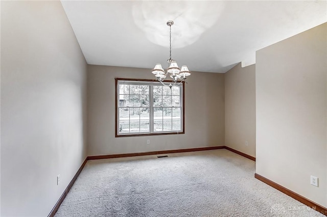 empty room with a notable chandelier and carpet flooring