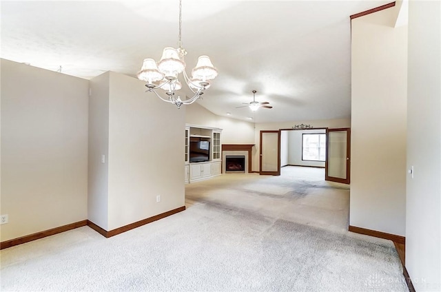 unfurnished living room with vaulted ceiling, ceiling fan with notable chandelier, and carpet floors