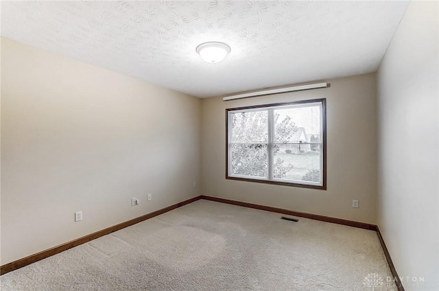 carpeted spare room with a textured ceiling