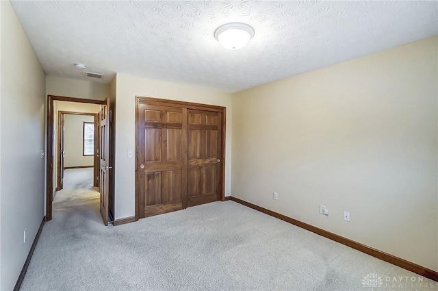 unfurnished bedroom with a textured ceiling and carpet