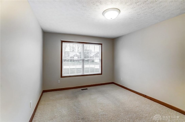 carpeted spare room featuring a textured ceiling