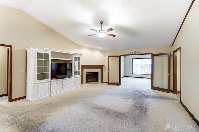 unfurnished living room featuring light carpet, ceiling fan, vaulted ceiling, and french doors