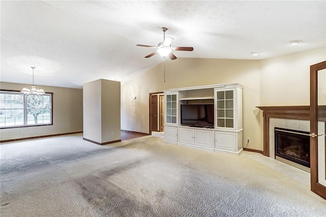 unfurnished living room featuring light colored carpet, lofted ceiling, ceiling fan with notable chandelier, and a tile fireplace