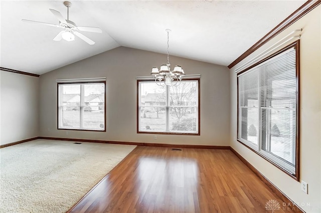 empty room with ceiling fan with notable chandelier, light hardwood / wood-style floors, and lofted ceiling