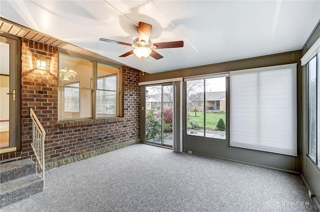 interior space featuring ceiling fan, brick wall, and carpet floors