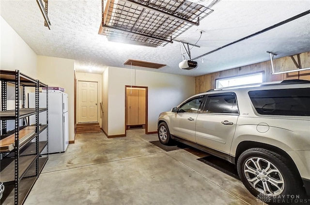 garage featuring a garage door opener and white fridge