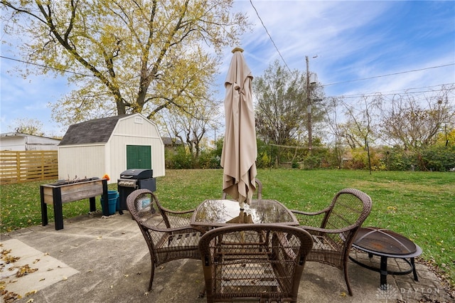 view of patio featuring a fire pit, a storage shed, and grilling area