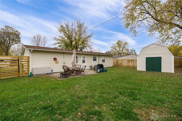 rear view of property featuring a patio area, a yard, a shed, and an outdoor fire pit