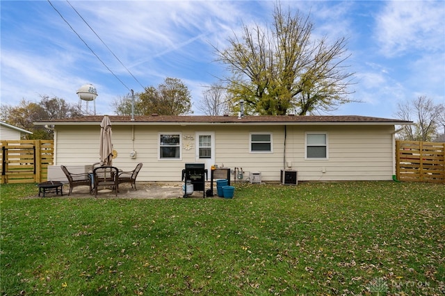 back of property with a yard, cooling unit, and a patio area