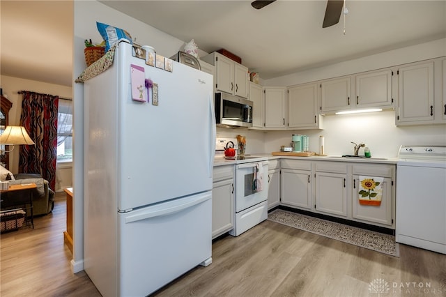 kitchen with washer / dryer, white appliances, light hardwood / wood-style flooring, and white cabinetry