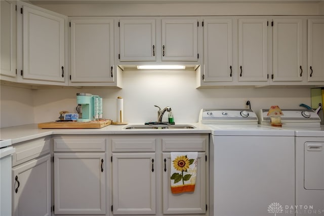 laundry room featuring cabinets, independent washer and dryer, and sink