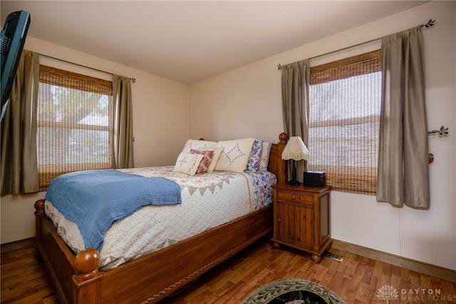 bedroom with wood-type flooring and multiple windows