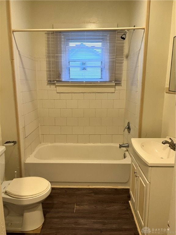 full bathroom featuring toilet, vanity, tiled shower / bath combo, and hardwood / wood-style flooring